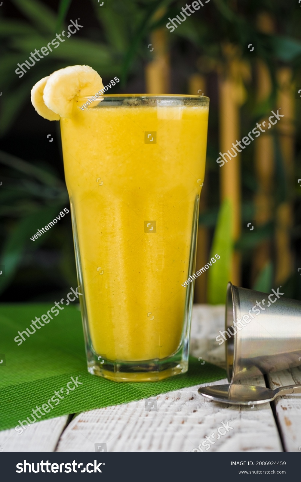 Glass of fruit juice on a table in the summer garden. #2086924459