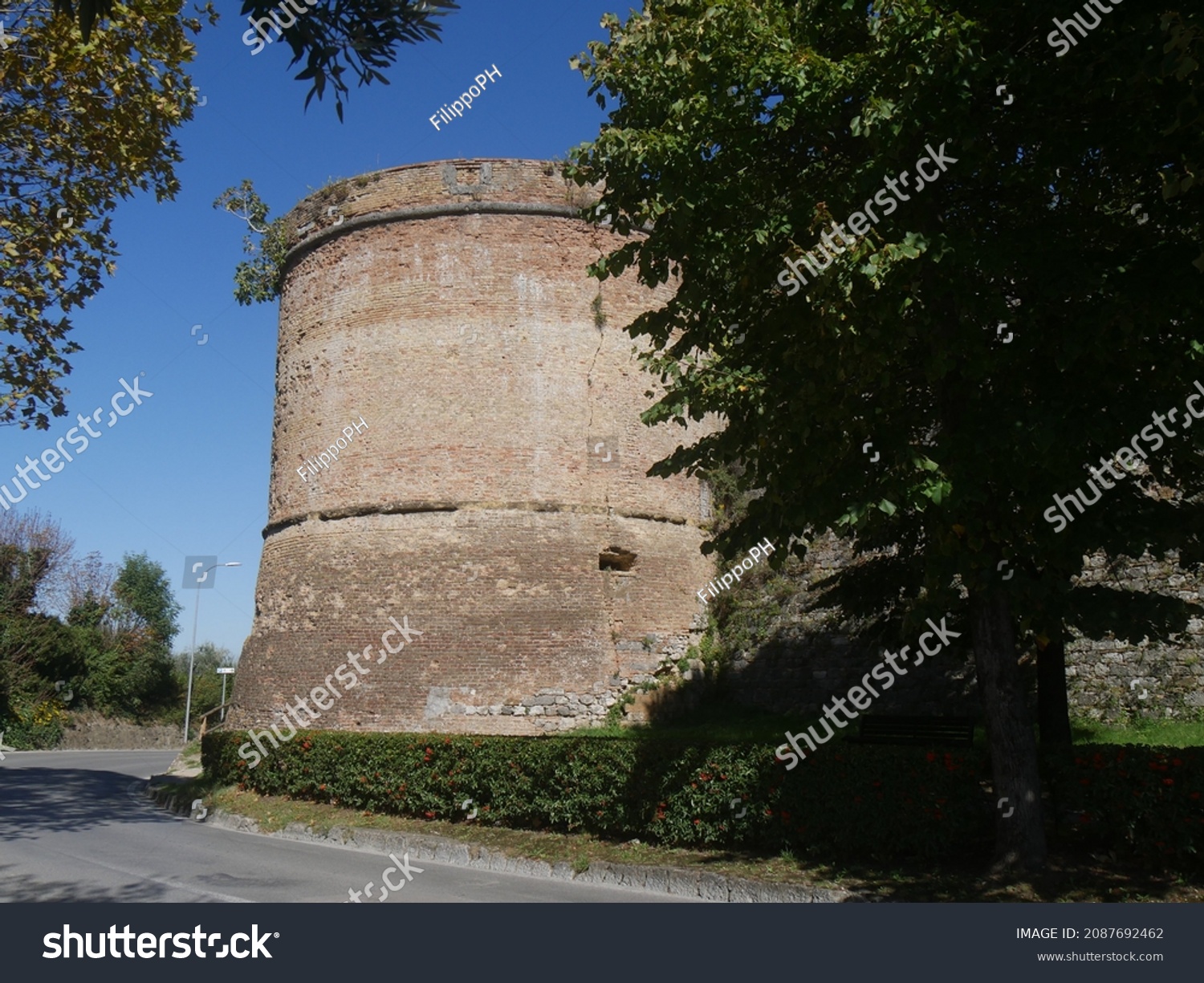 walls with towers and bulwarks that surround the old town of San Gimignano #2087692462