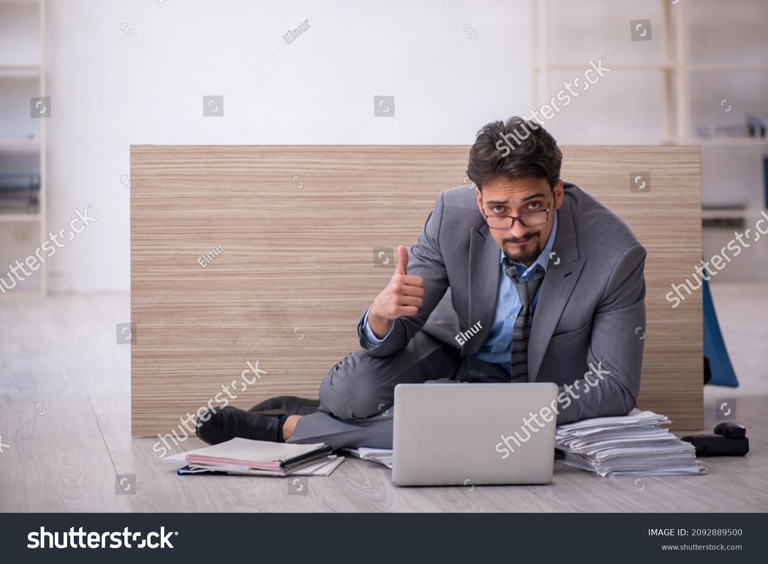 Young male employee working overtime in the office #2092889500