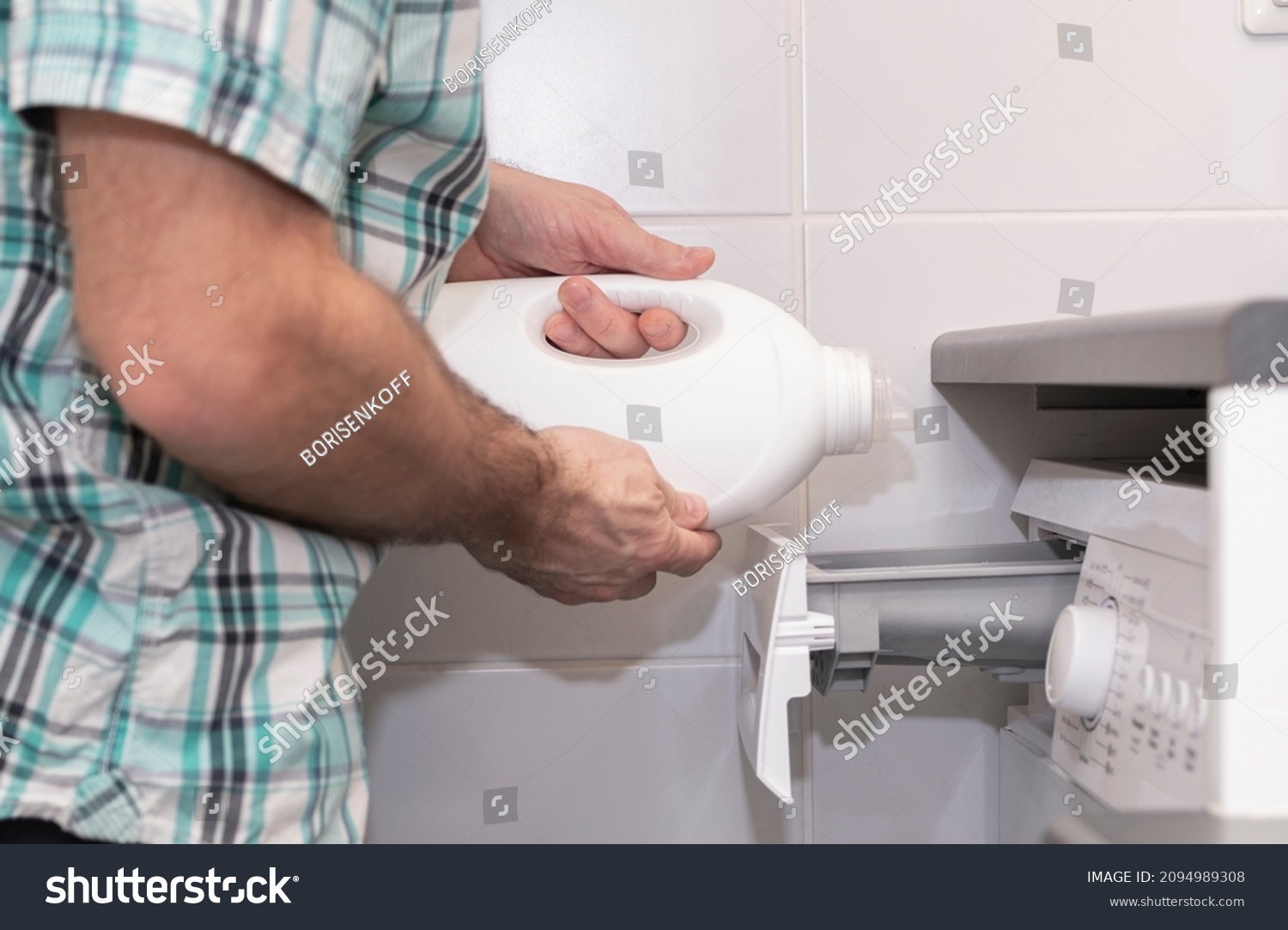 Mudchina, a Caucasian, middle-aged, pours bleach into the washing machine for washing clothes. #2094989308
