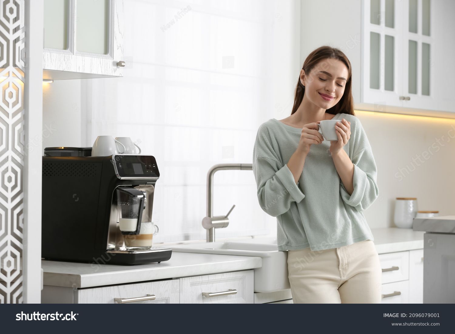 Young woman enjoying fresh aromatic coffee near modern machine in kitchen #2096079001