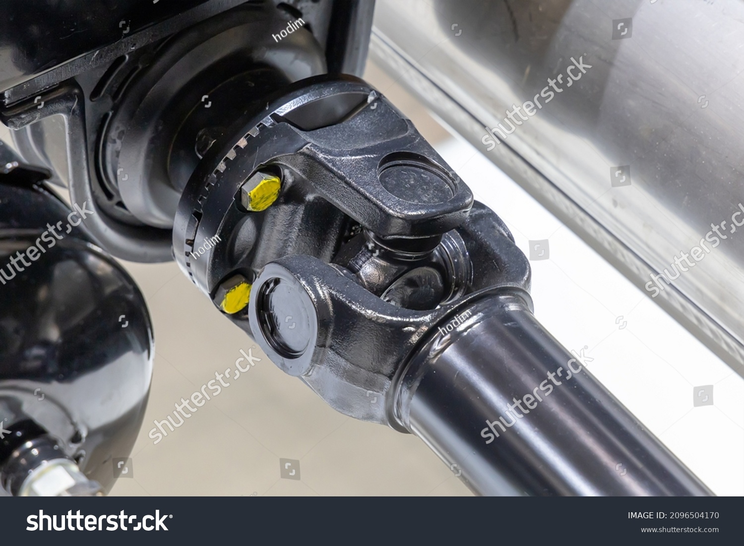 Closeup of a car cardan drive shaft with cardan cross joint and intermediate bearing support. Also known as universal joint, u-joint or cardan joint. Part of the transmission of a truck #2096504170