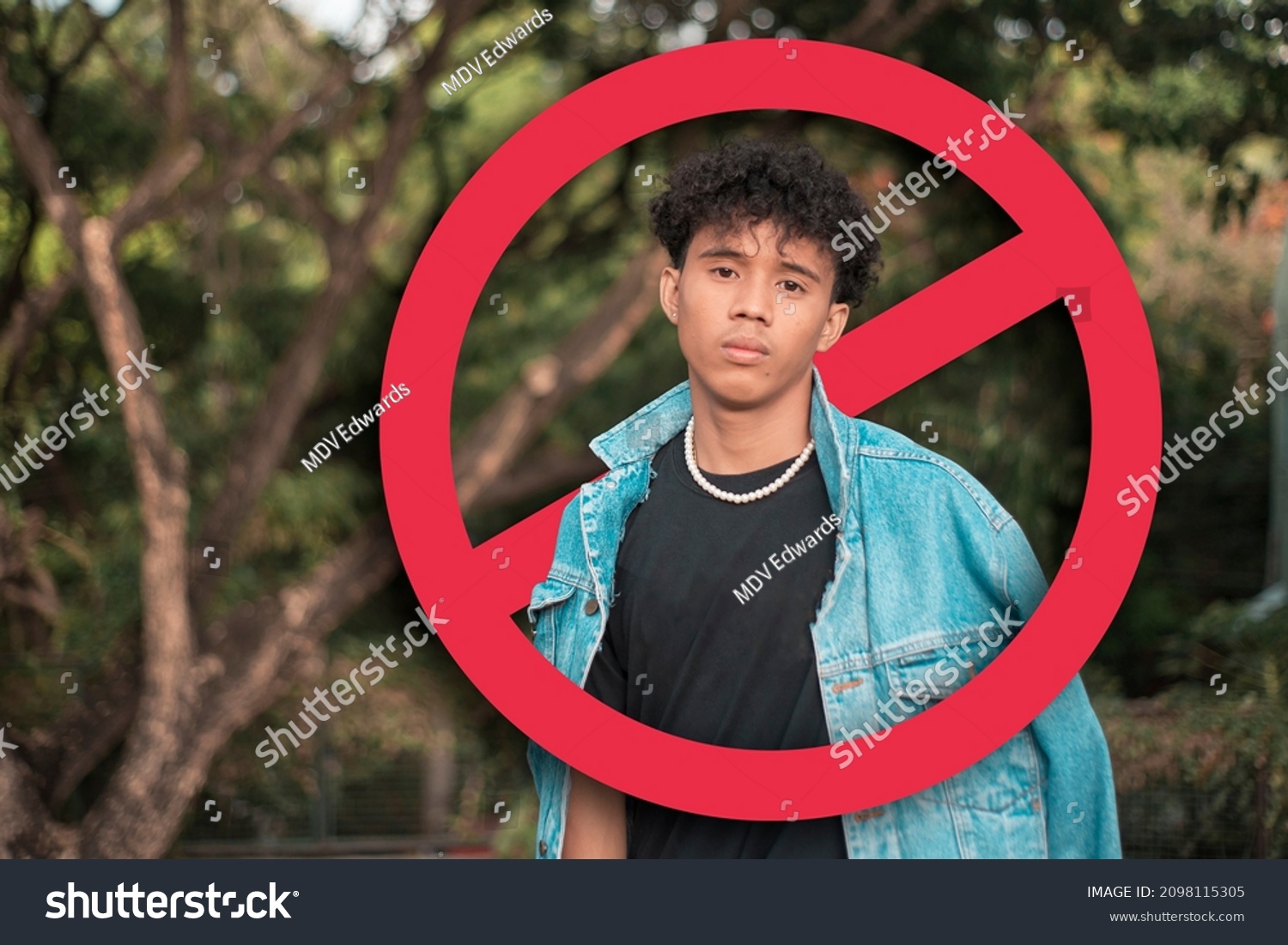 A depressed young man after being called out, shunned or blocked in social media or in person. Cancel culture concept. With stop sign graphic. #2098115305
