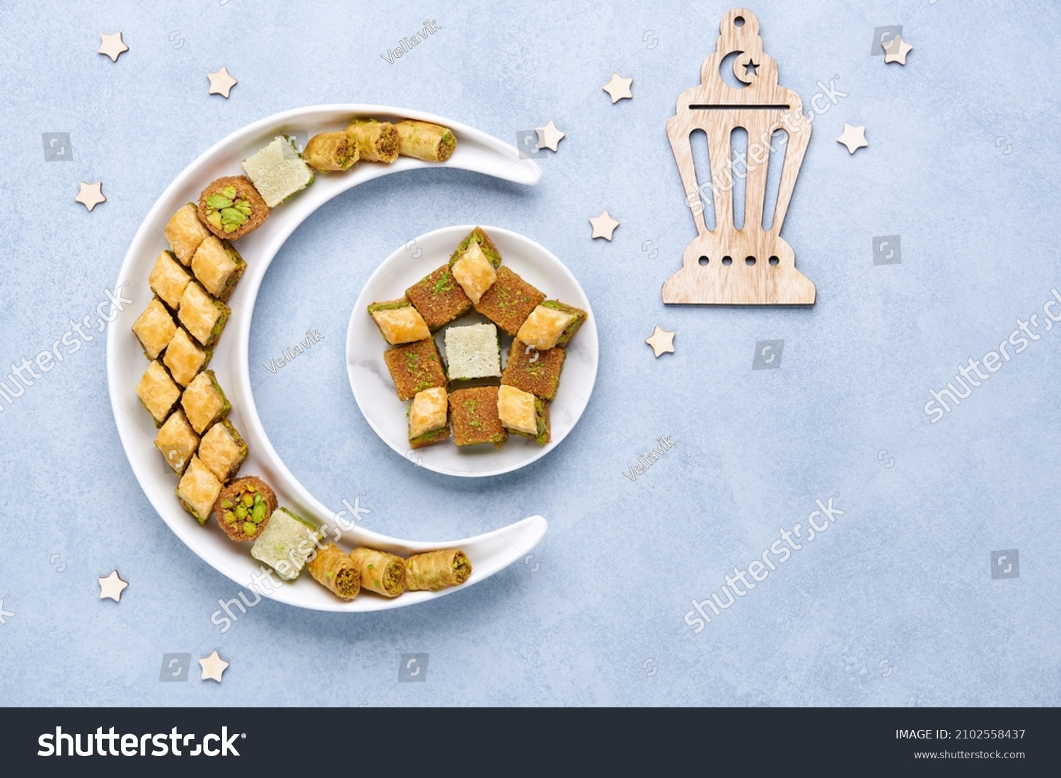 Traditional middle eastern dessert baklava in shape of moon and star . Ramadan background with sweets and lantern   , Top view, flat lay , copy space                          #2102558437