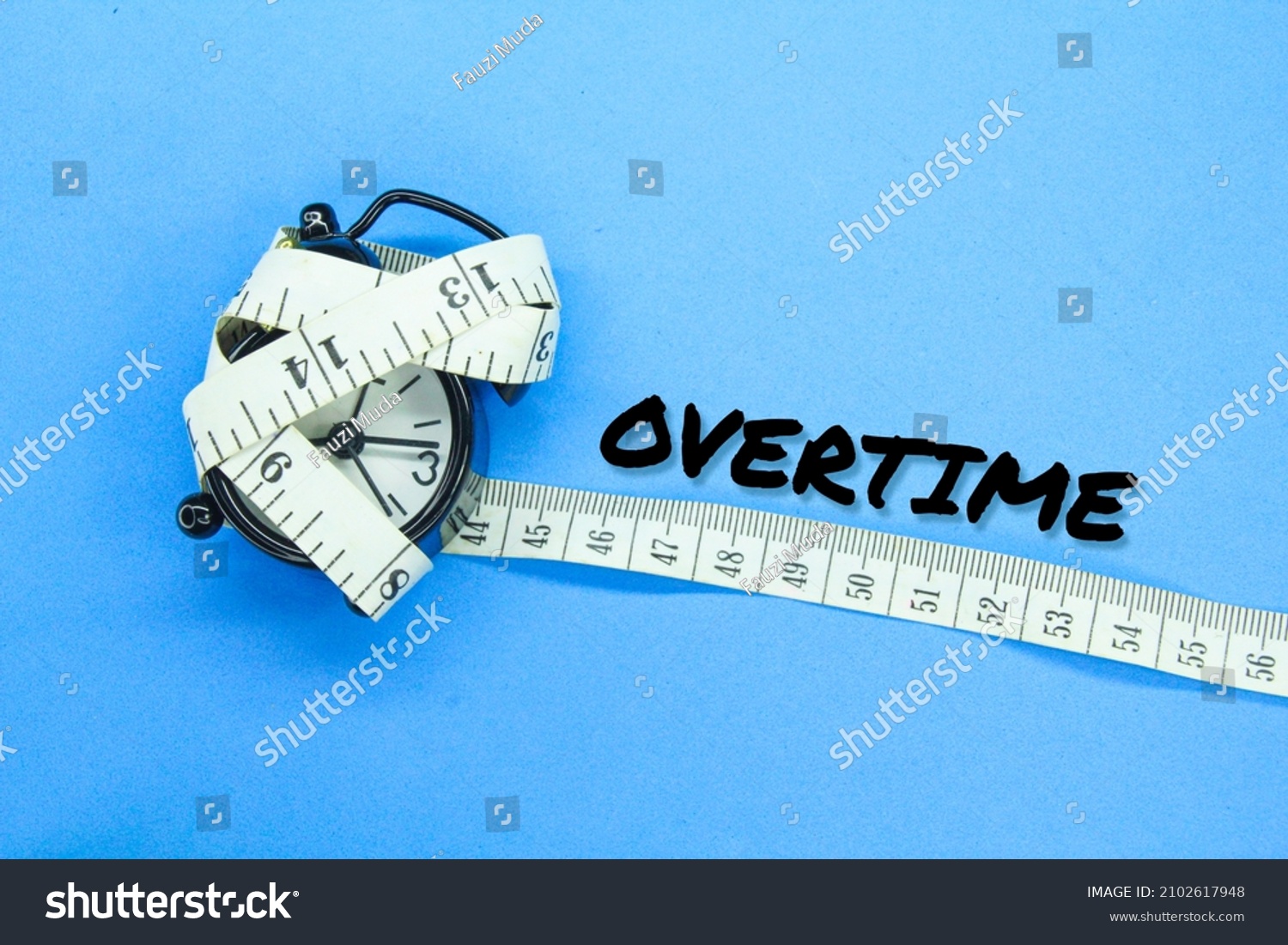the alarm clock is wrapped with measuring tape with the word overtime #2102617948