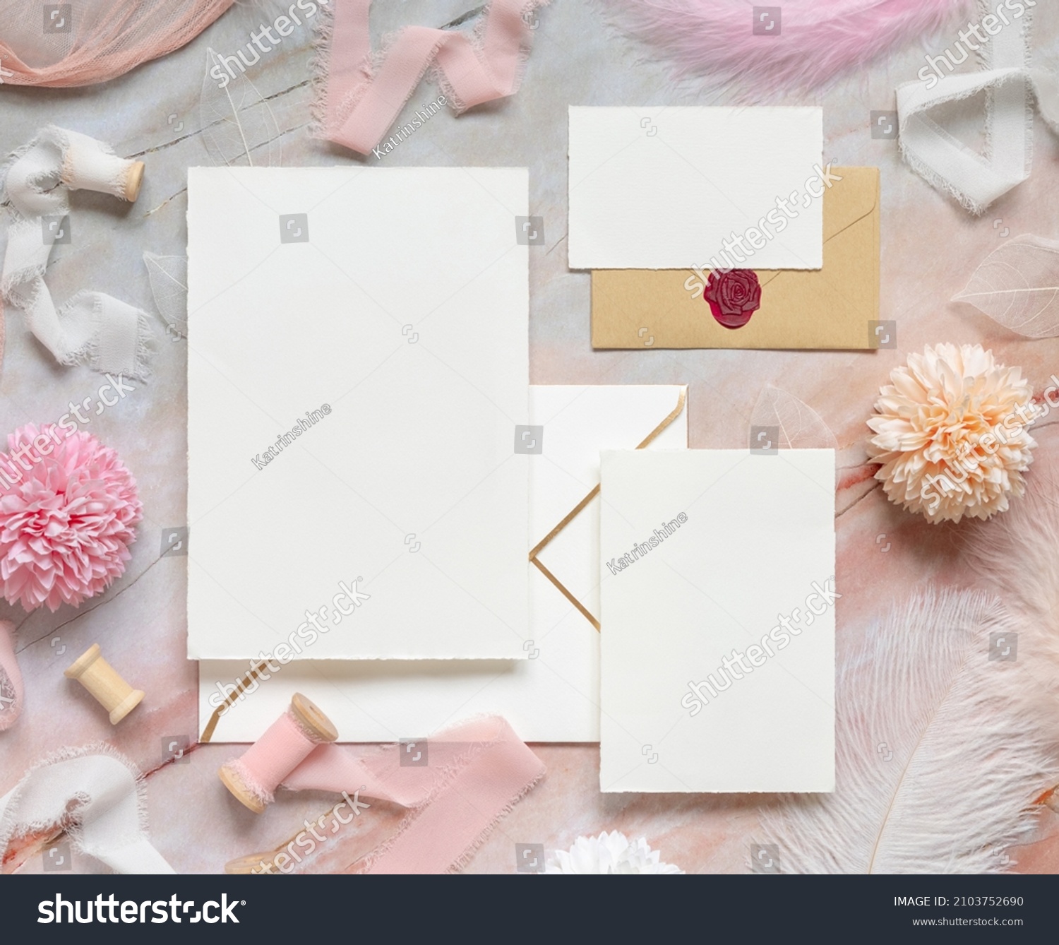 Blank cards and envelopes between pastel flowers, silk ribbons and feathers on marble top view. Romantic scene with wedding suite mockups flat lay,  place for text. Valentines, Spring #2103752690