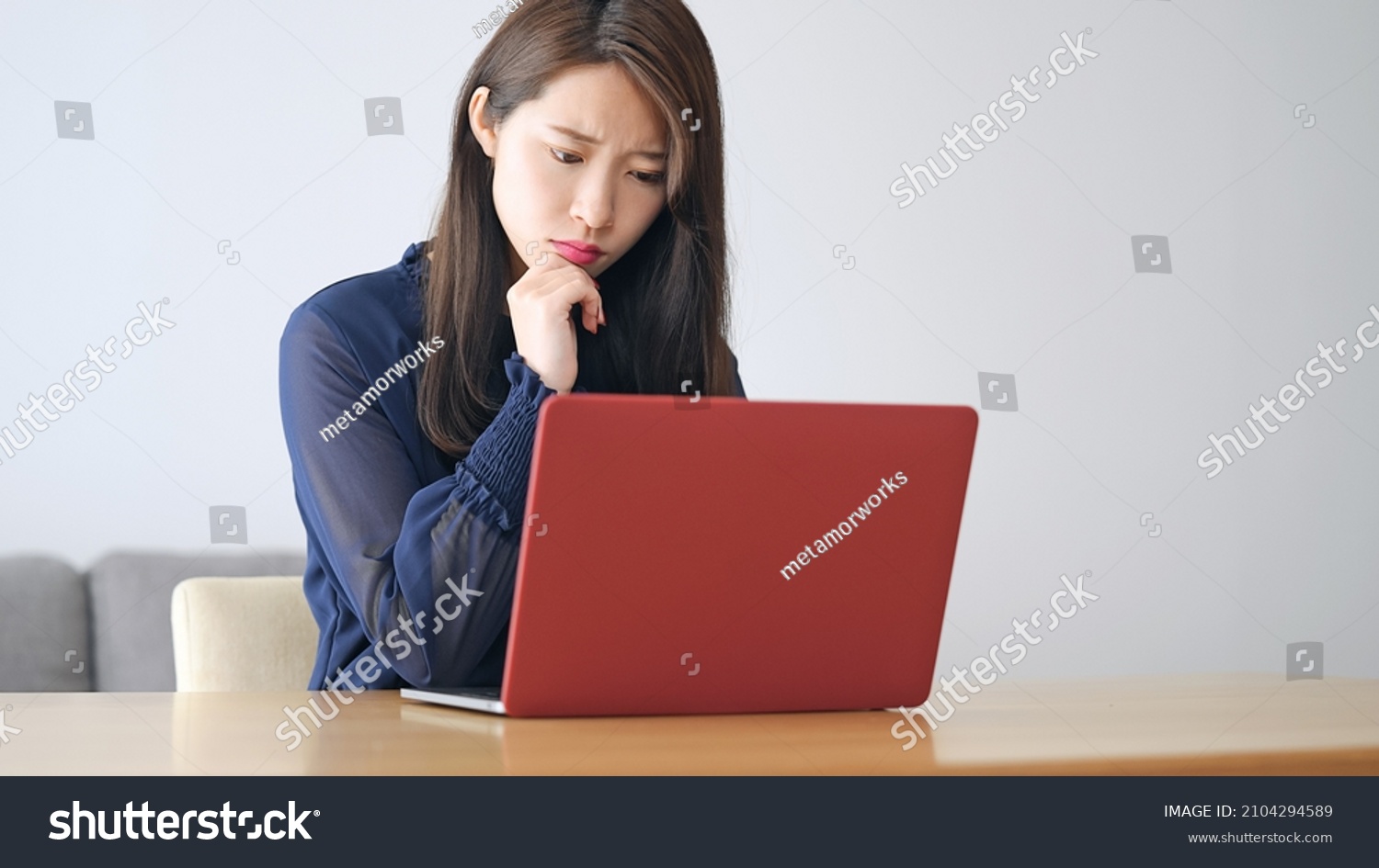 Worrying young Asian woman using a laptop PC. #2104294589