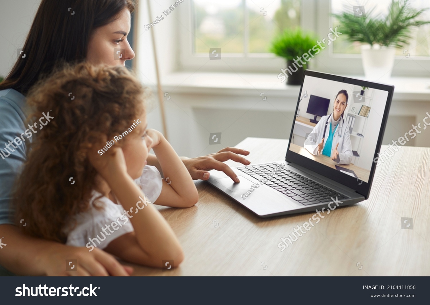 Healthy mother and child enjoying digital era, having online telemedicine consultation with remote doctor or watching educational video by professional paediatrician about cold and flu virus treatment #2104411850
