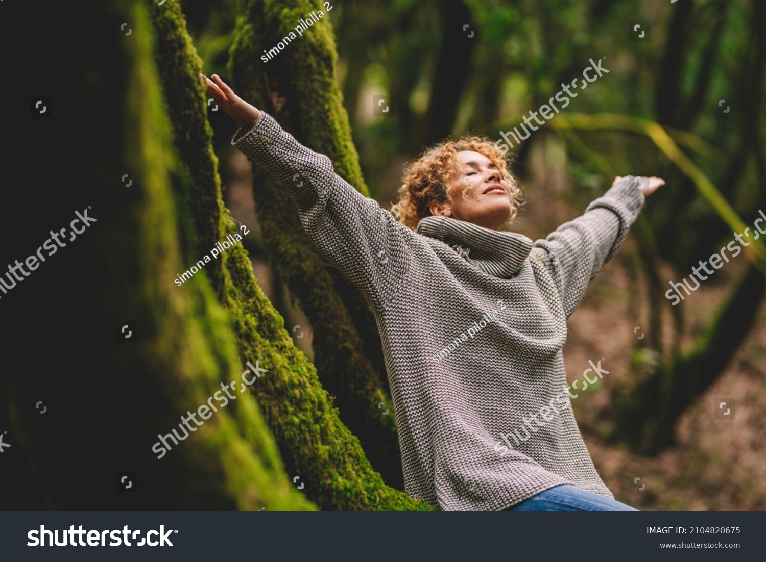 Overjoyed happy woman enjoying the green beautiful nature woods forest around her - concept of female people and healthy natural lifestyle - happiness emotion and adult lady opening arms  #2104820675