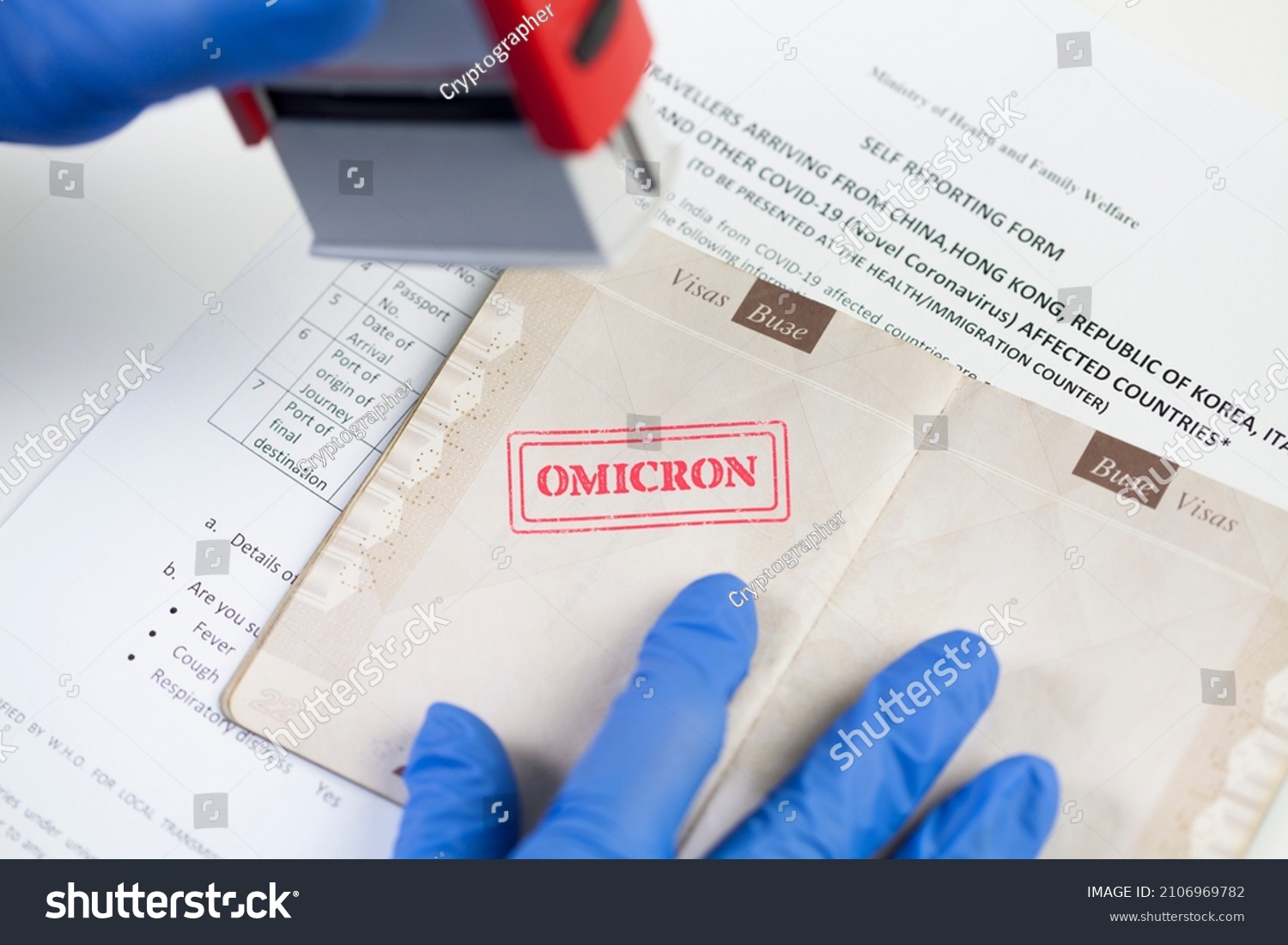 Border security officer wearing blue protective gloves stamping OMICRON onto document,airport border customs health and safety security check,safety measures due to outbreak of new Coronavirus variant #2106969782