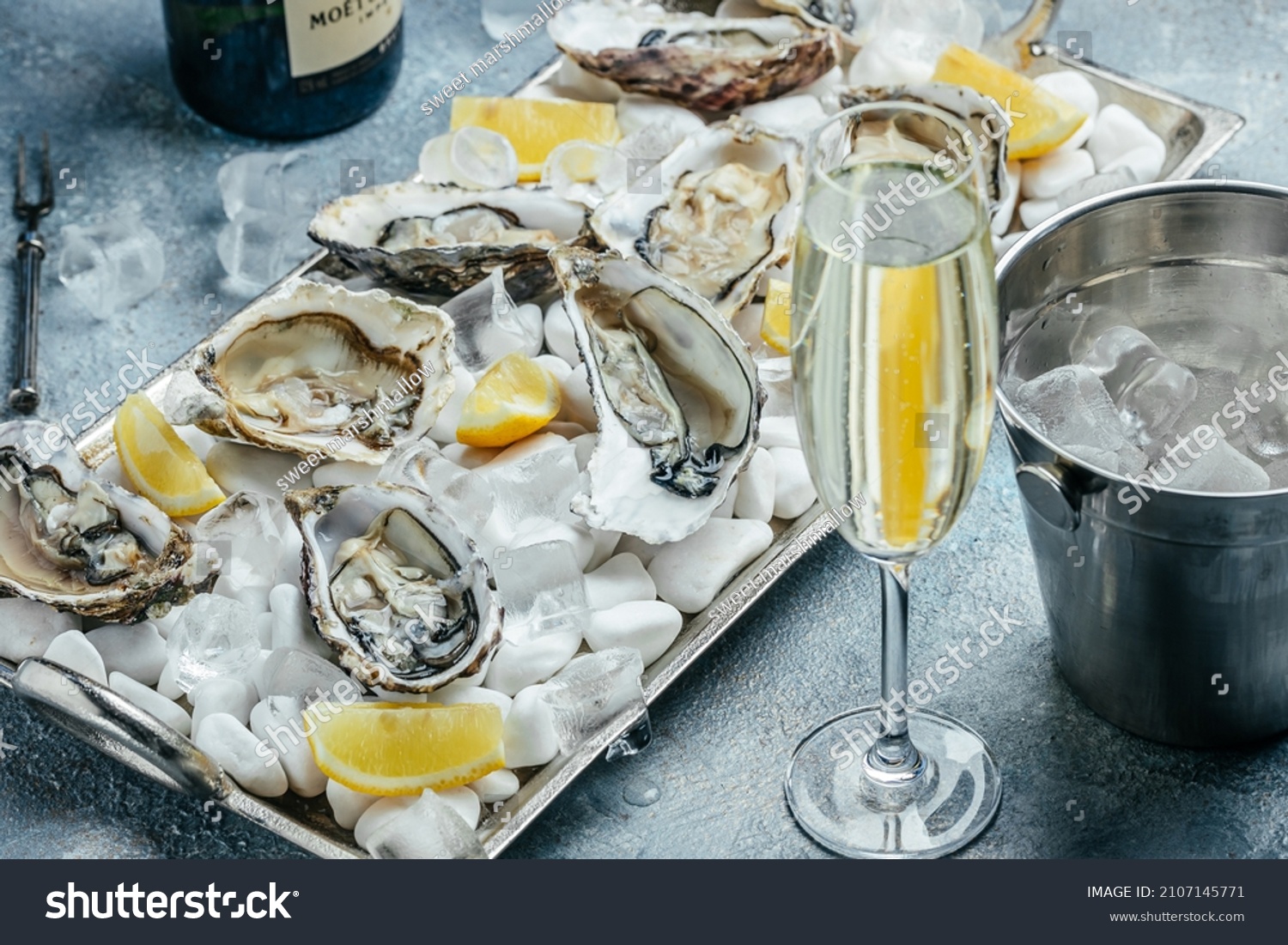 Oysters with wine, lemon, and ice. oysters dish. Oyster dinner with champagne in restaurant. banner, menu, recipe place for text, top view. #2107145771