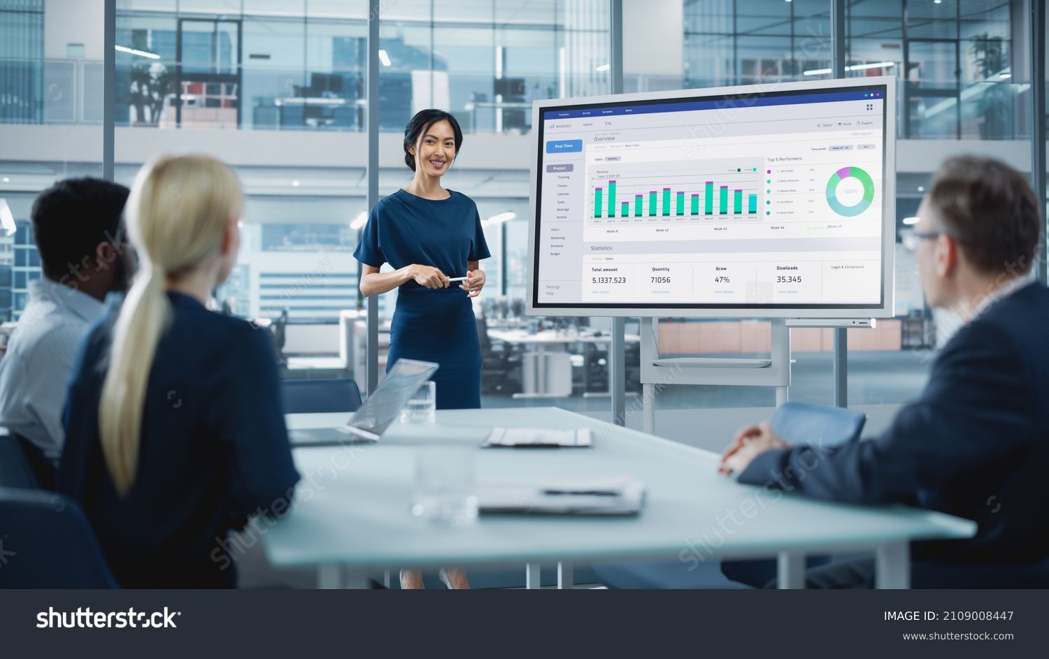 Female Operations Manager Holds Meeting Presentation for a Team of Economists. Asian Woman Uses Digital Whiteboard with Growth Analysis, Charts, Statistics and Data. People Work in Business Office. #2109008447