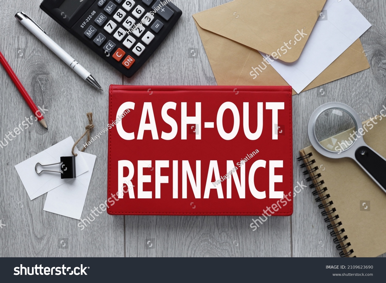 CASH-OUT REFINANCE red notepad on wood background with envelope and calculator #2109623690