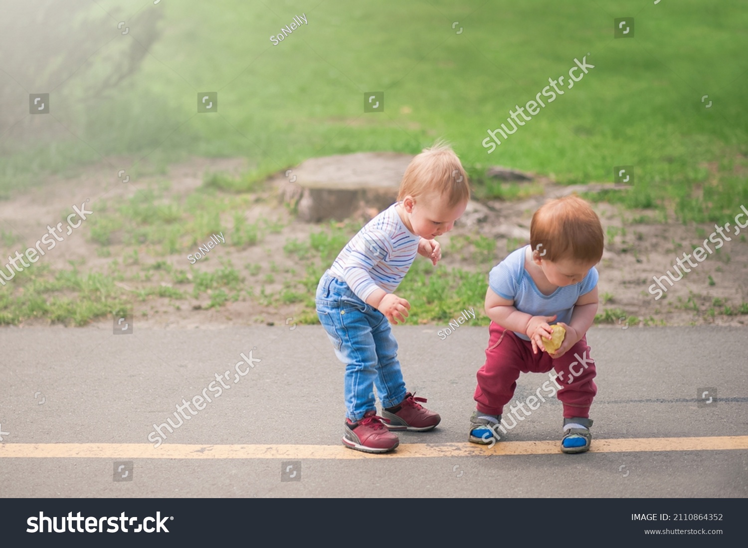 Toddler boys walk and play outside in spring.. #2110864352