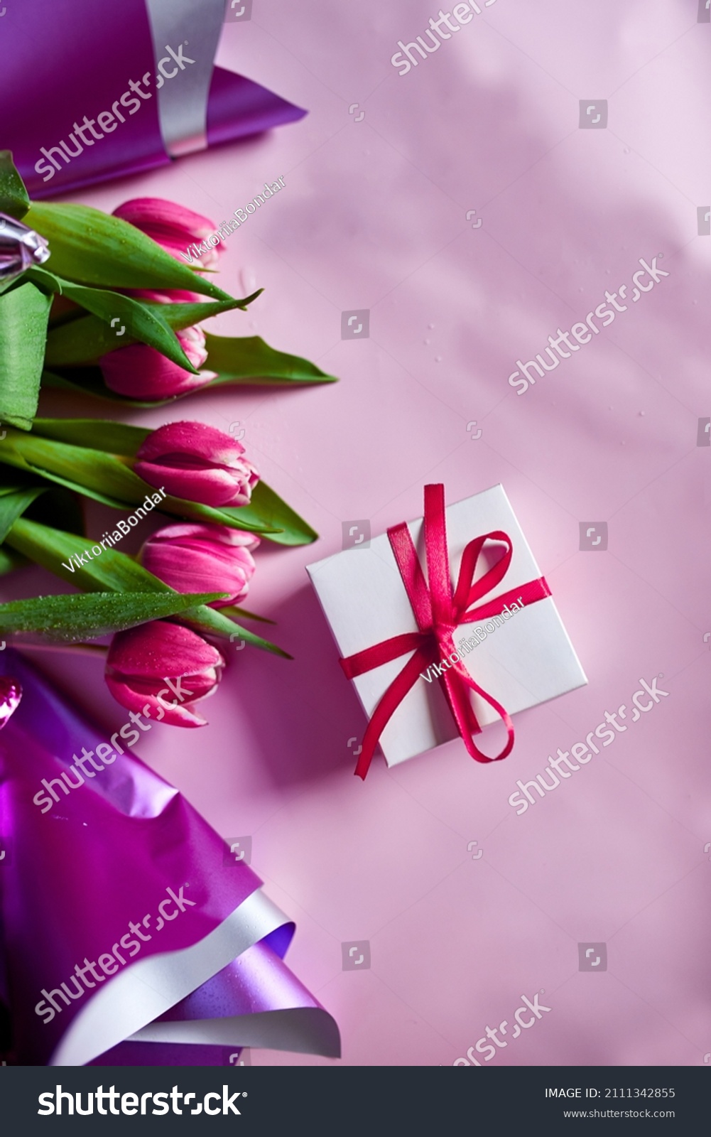 Top view pink tulips flowers in violet paper wrapper with gift box, festive background, concept of Happy Mother's day, Woman's day, birthday, 8 March, Valentines day #2111342855