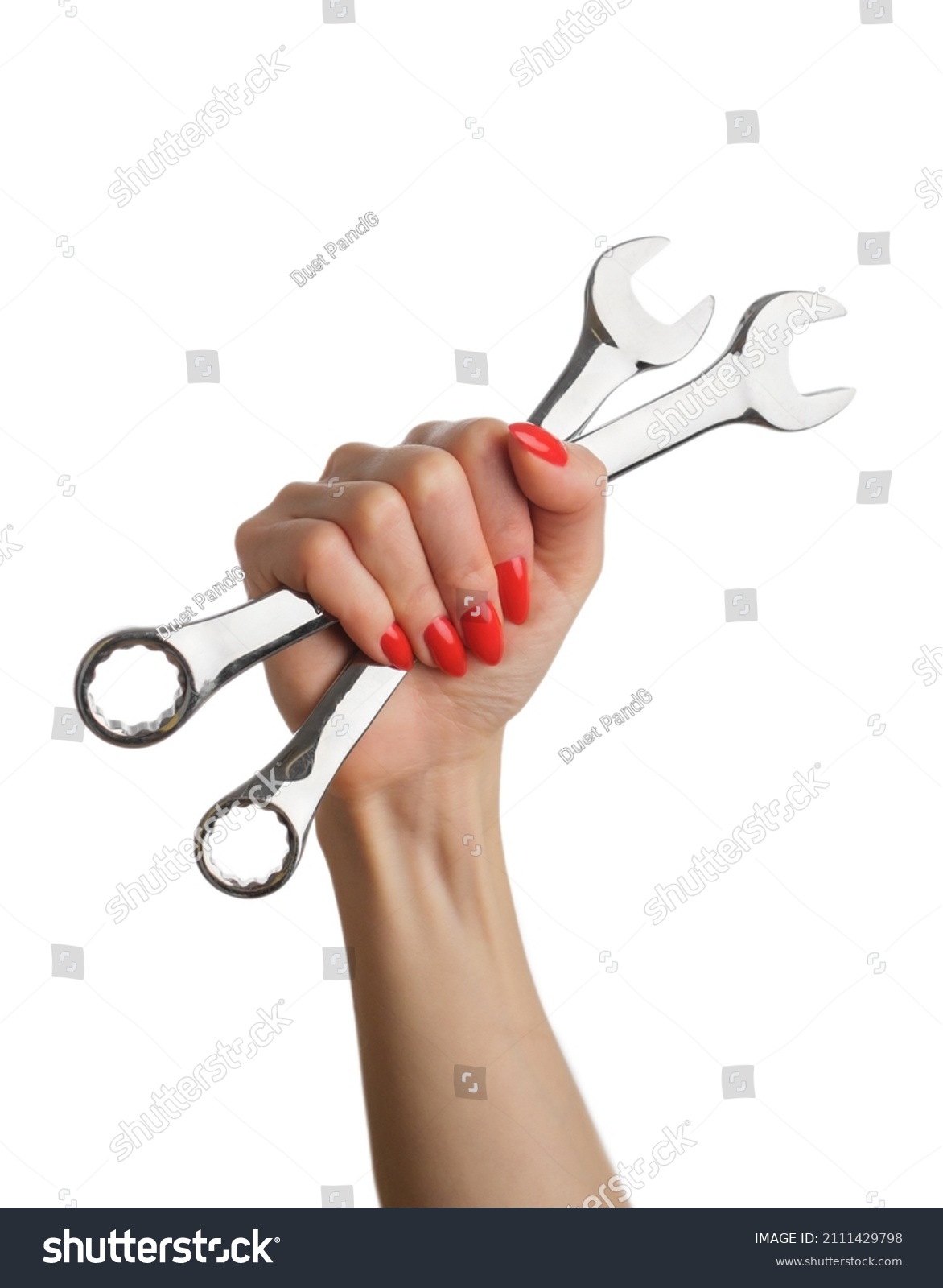 Woman's hand with a red manicure and a wrench on an isolated white background. #2111429798
