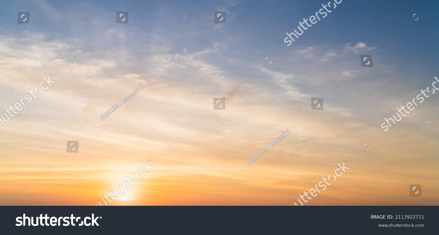 Evening, Colorful sunset sky background in Golden Sky Hour with Romantic Orange, Yellow sunlight clouds   #2113922711