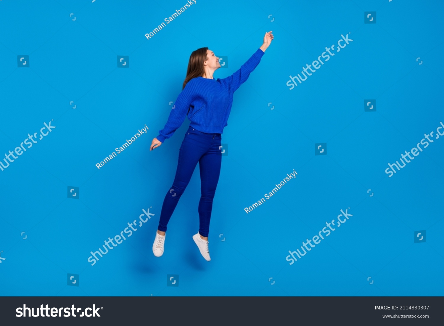 Full length body size view of attractive cheerful girl jumping holding copy space isolated on bright blue color background #2114830307