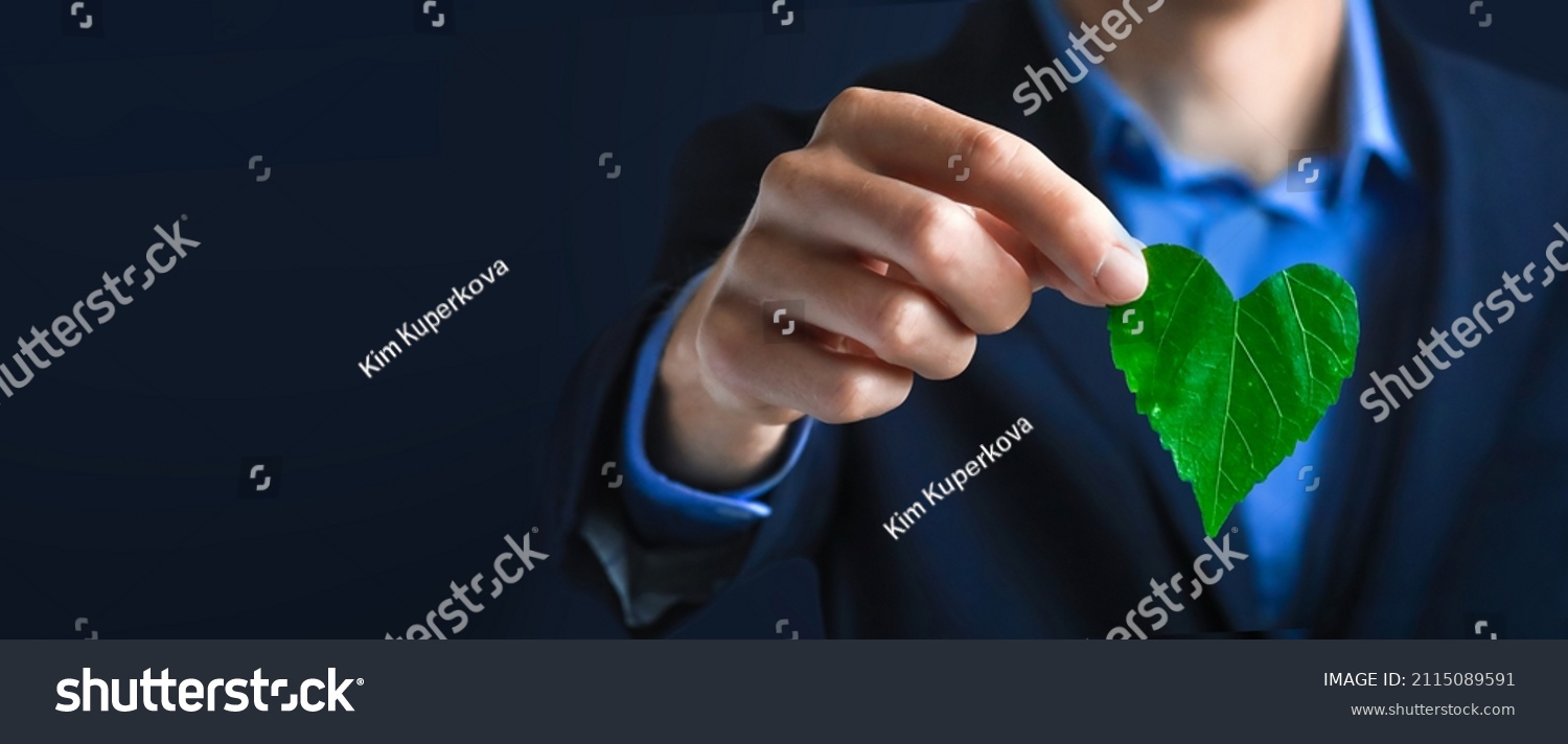 Businessman holding a green heart leaf  Business with corporate social responsibility and environmental concern. Environmental and Ecology Care Concept.. ESG Concept. Nature  #2115089591