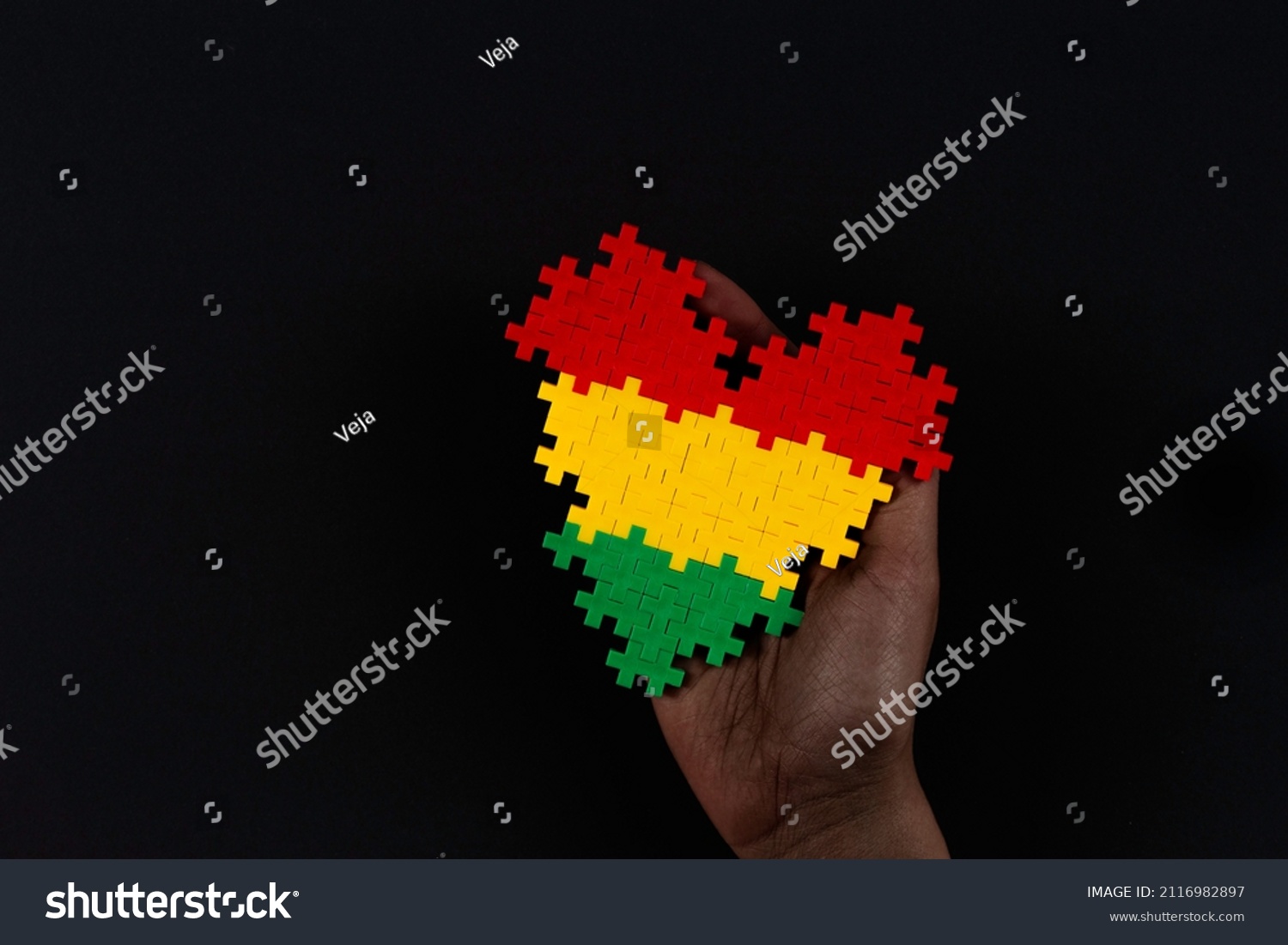 Black History Month background. African American history month celebration. Hand holding heart in red, yellow, green colors flag over black background #2116982897