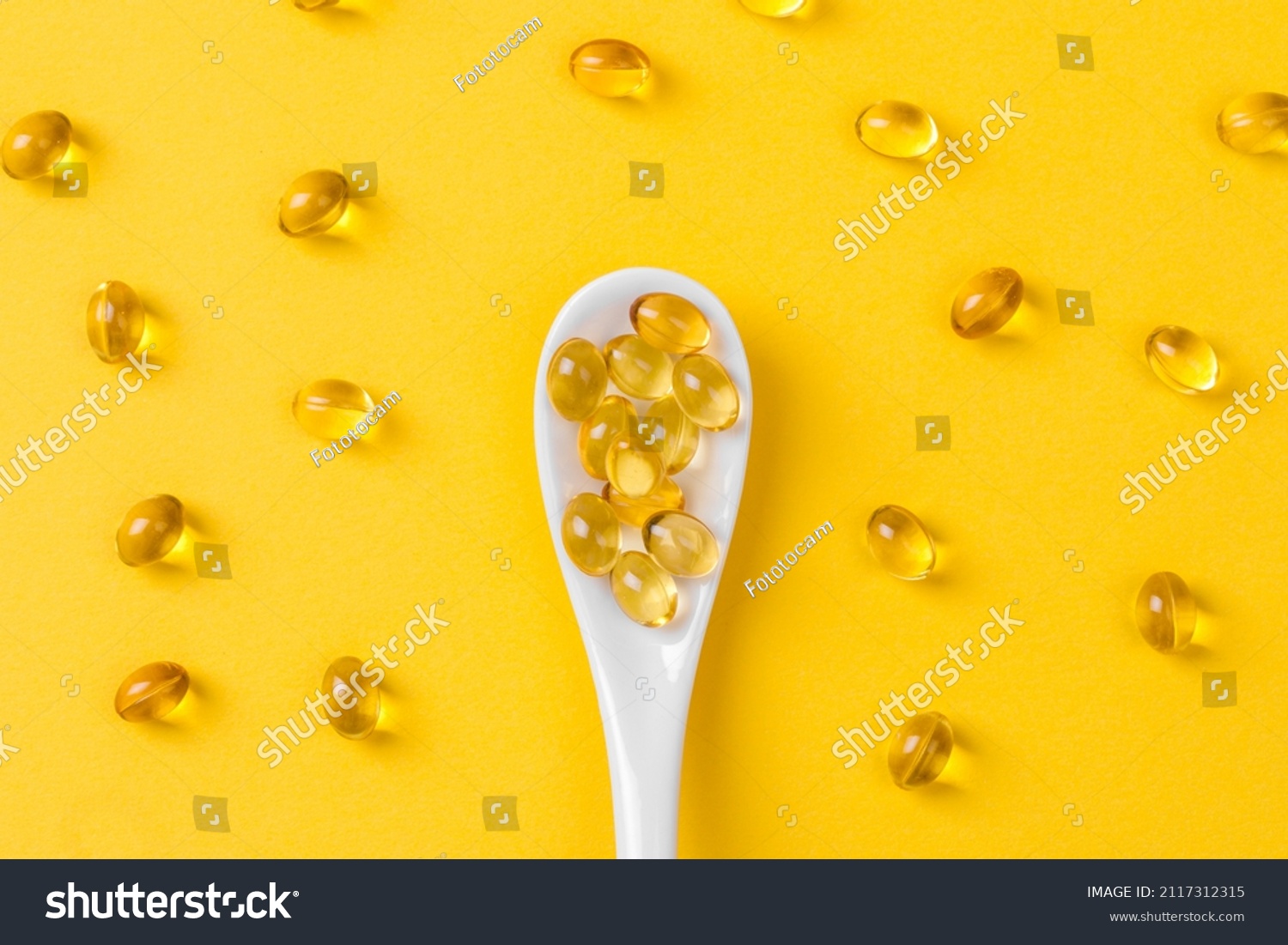 Close up of  oil filled capsules on spoon suitable for: fish oil, omega 3, omega 6, omega 9,  vitamin A, vitamin D, vitamin D3, vitamin E  #2117312315
