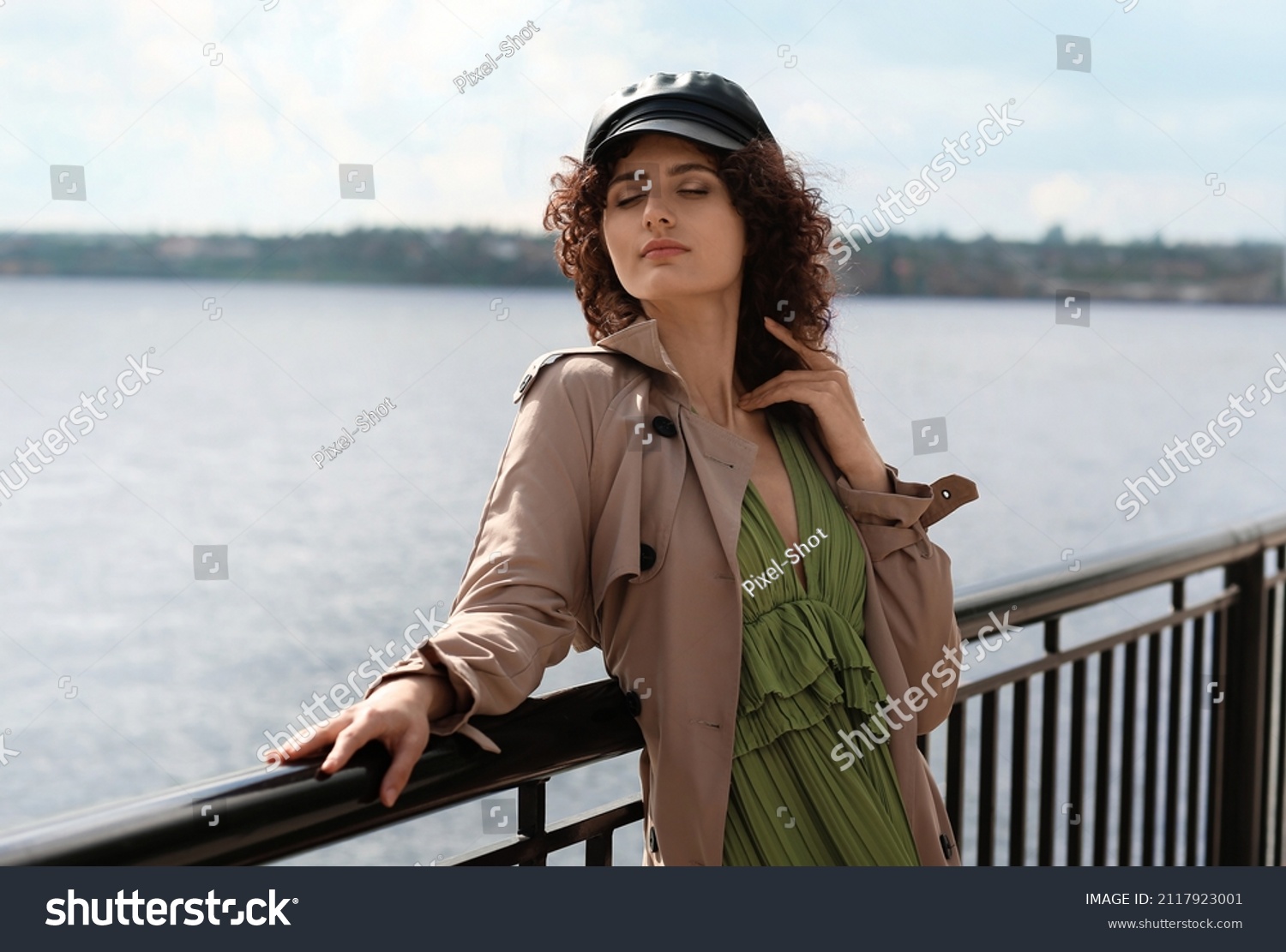 Young woman in leather cap enjoining sunny day outdoors #2117923001