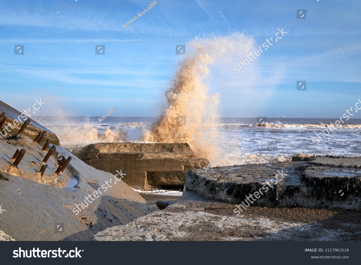 Waves crashing over rocks on a beach
 #2117963516