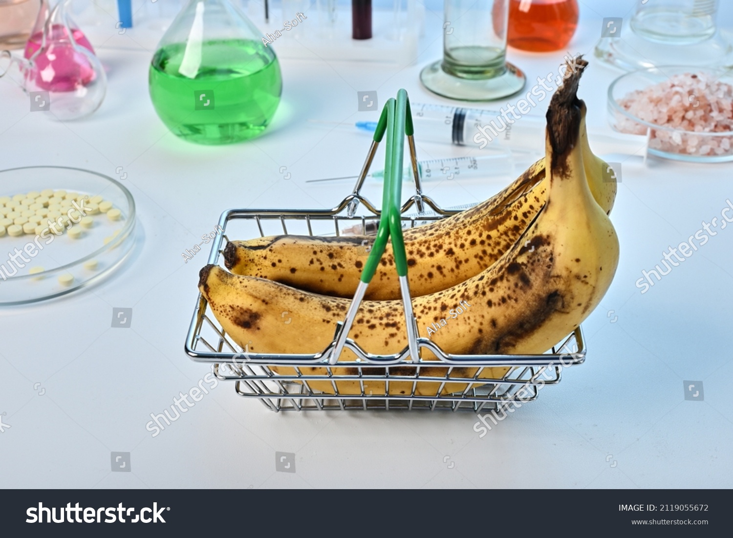Bananas in metal basket - labs photo. Two yellow ripe bananas in metallic toy basket. Food control laboratory of fruit safety. Chemical expertize of exotic fruits for GMO nutriments. Diet analysis. #2119055672