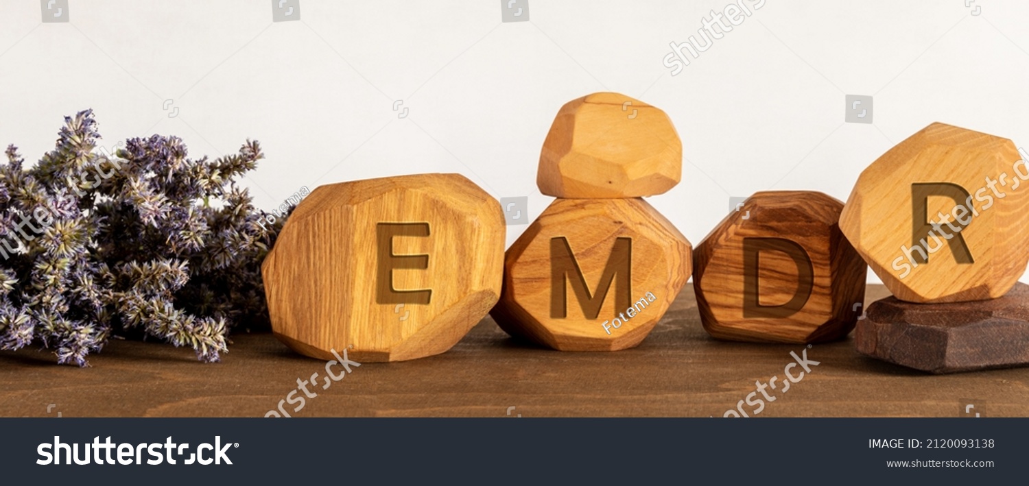 Eye Movement Desensitization and Reprocessing psychotherapy treatment concept. Letters EMDR written on wooden irregular blocks. #2120093138