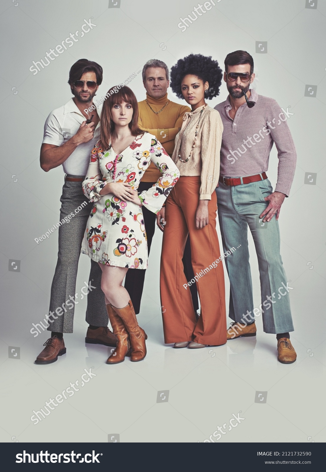 Nothing like some 70s style. A studio shot of a group of people standing together while clad in retro 70s wear. #2121732590