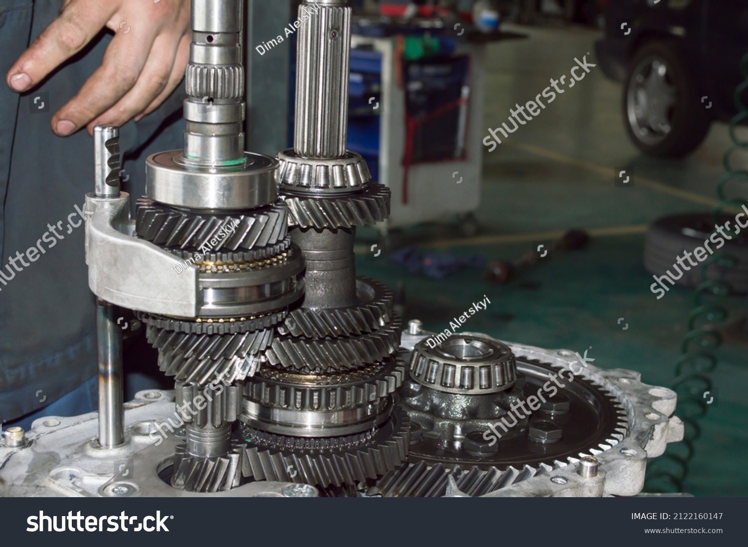 Side view of shafts and gears of a partially disassembled mechanical transmission in an auto repair shop #2122160147