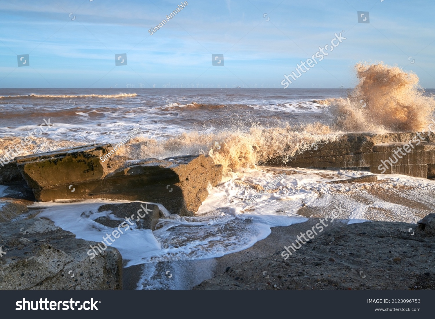 Waves crashing over rocks on a beach
 #2123096753