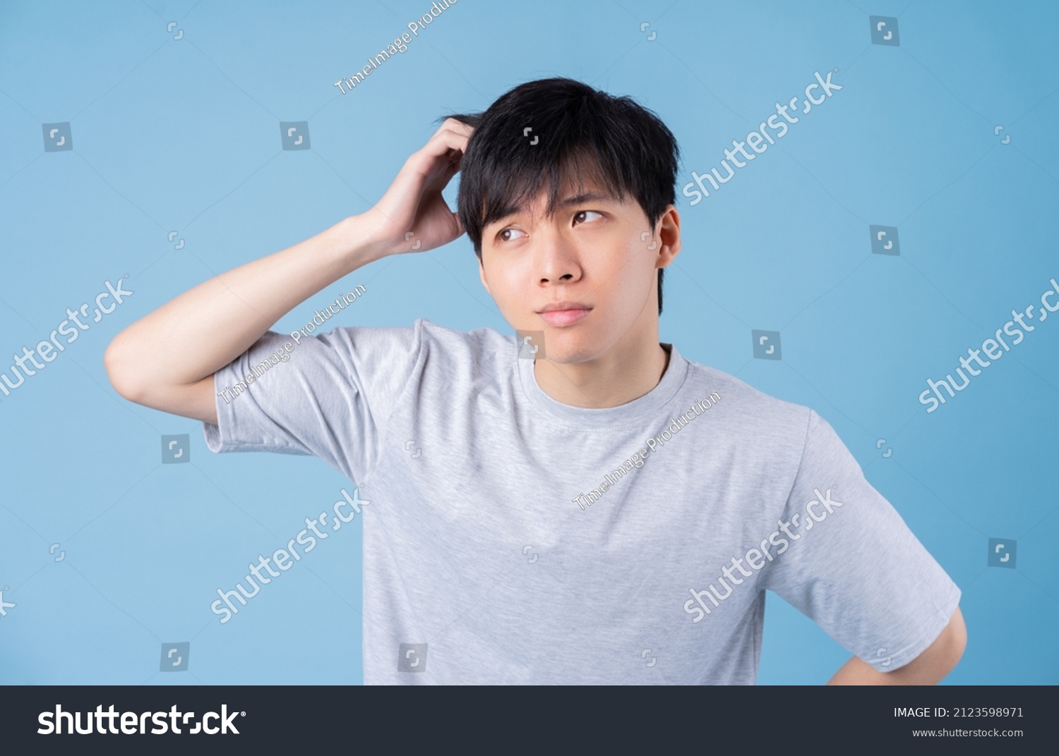 Young Asian man posing on blue background #2123598971