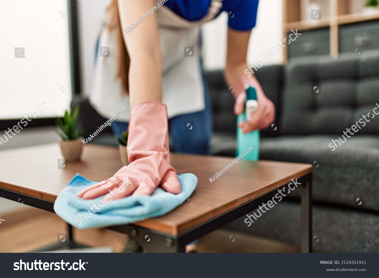 Woman cleaning table using rag and diffuser at home. #2124351911