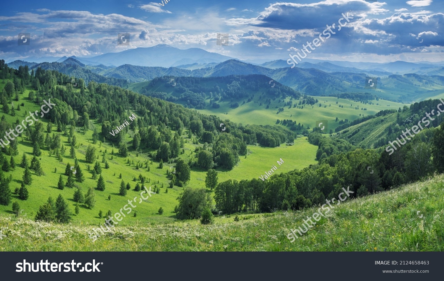 Picturesque valley, mountain view. Bright sunlight, spring greens of forests and meadows. #2124658463