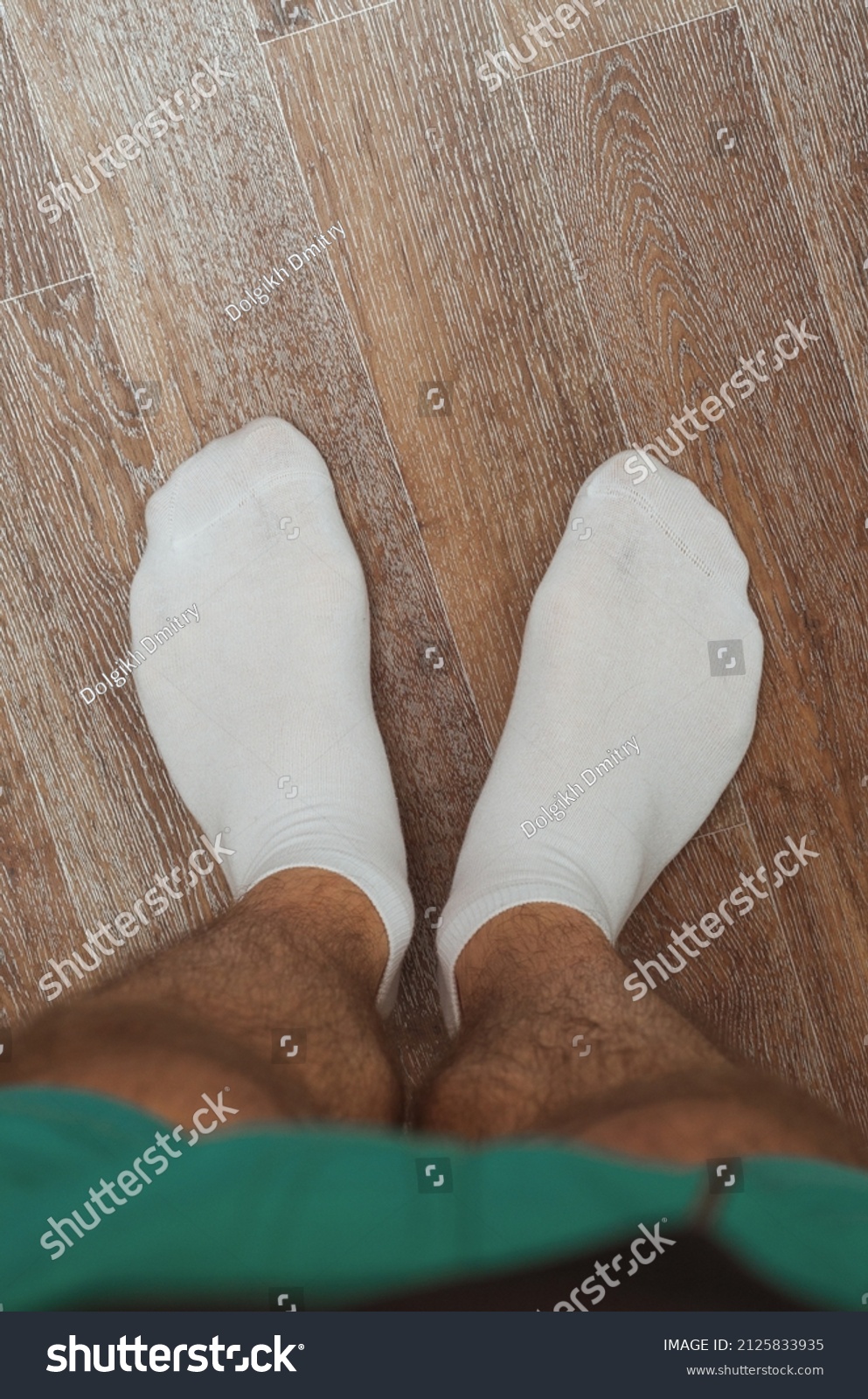 Hairy male legs on the floor in short white socks #2125833935