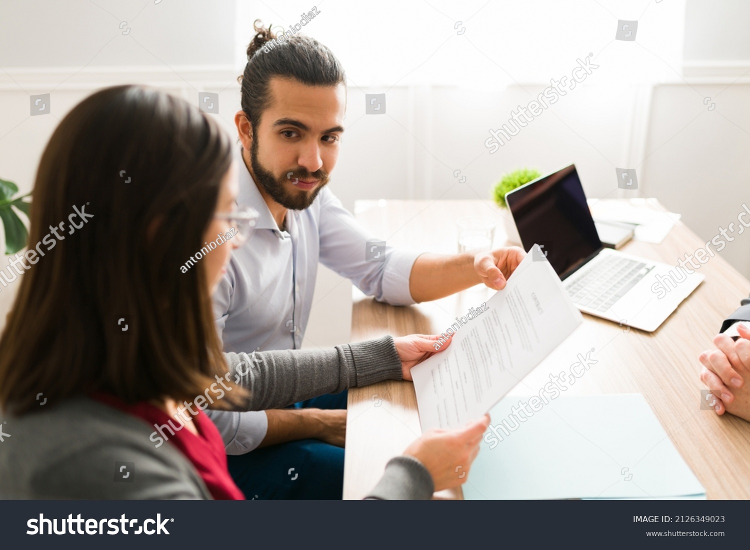 Newly married couple in their 30s signing the mortgage papers at an agent's office #2126349023