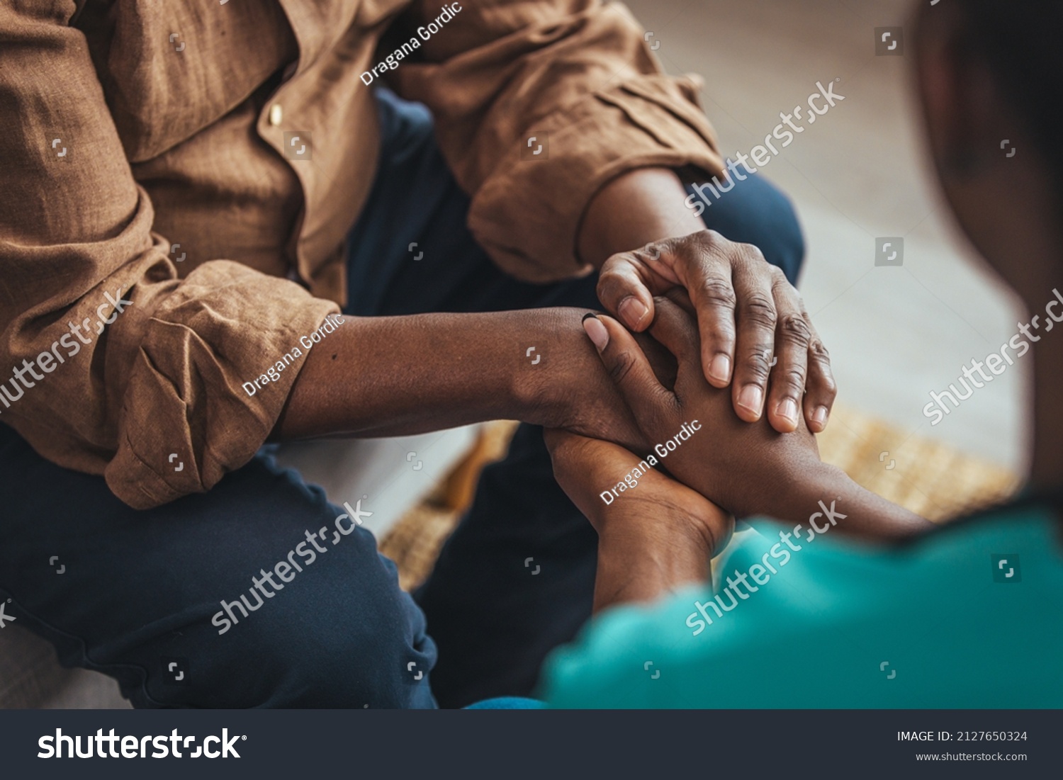 Closeup of a support hands. Closeup shot of a young woman holding a senior man's hands in comfort. Female carer holding hands of senior man  #2127650324