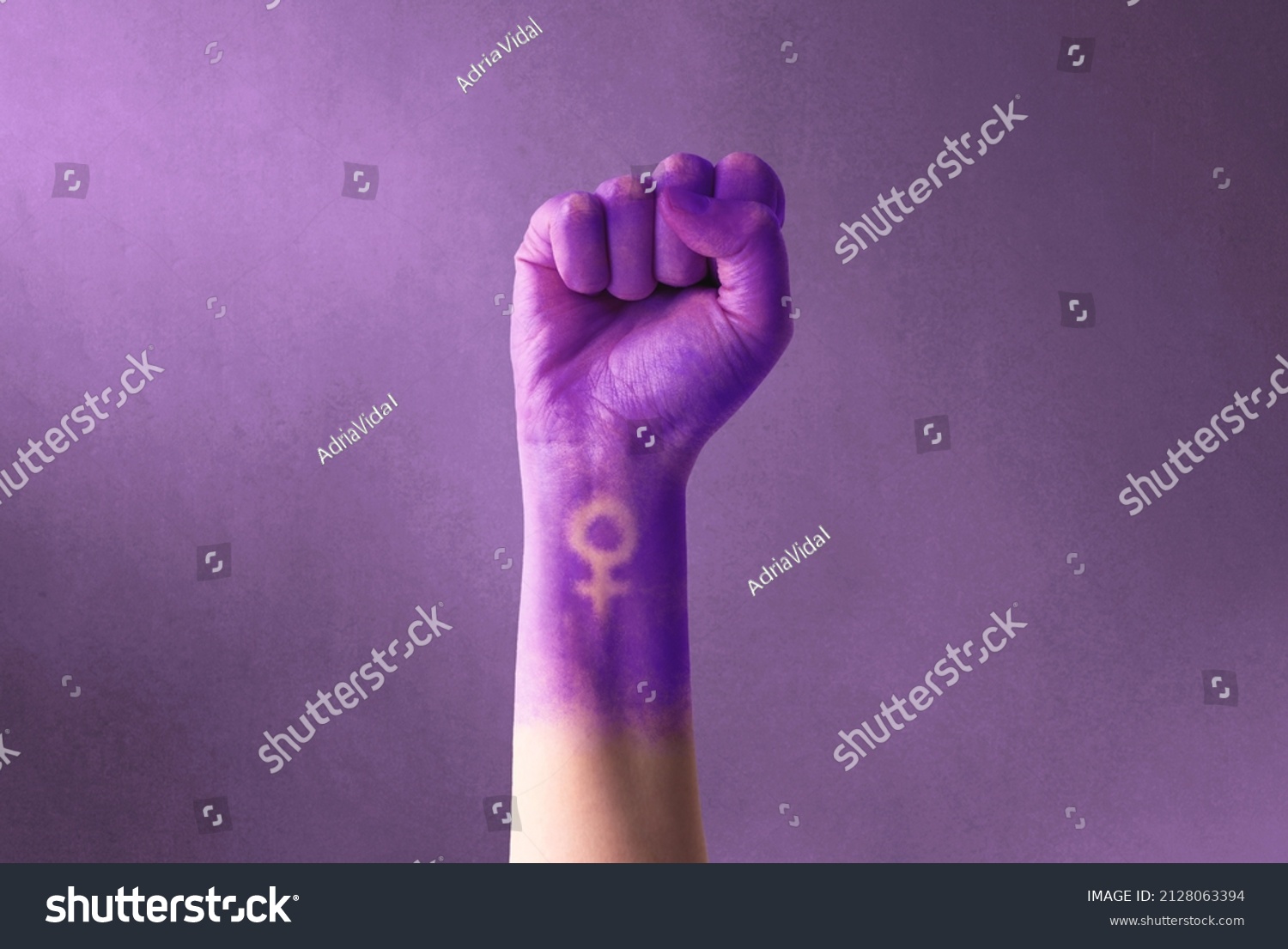 Raised purple fist of a woman for international women's day and the feminist movement. March 8 for feminism, independence, freedom, empowerment, and activism for women rights #2128063394