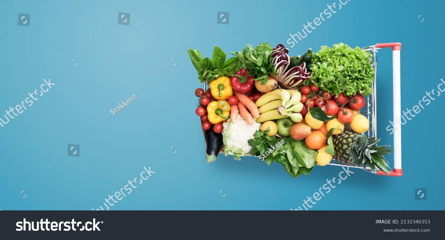 Supermarket shopping cart full of fresh vegetables and fruits, healthy organic food concept #2132340353