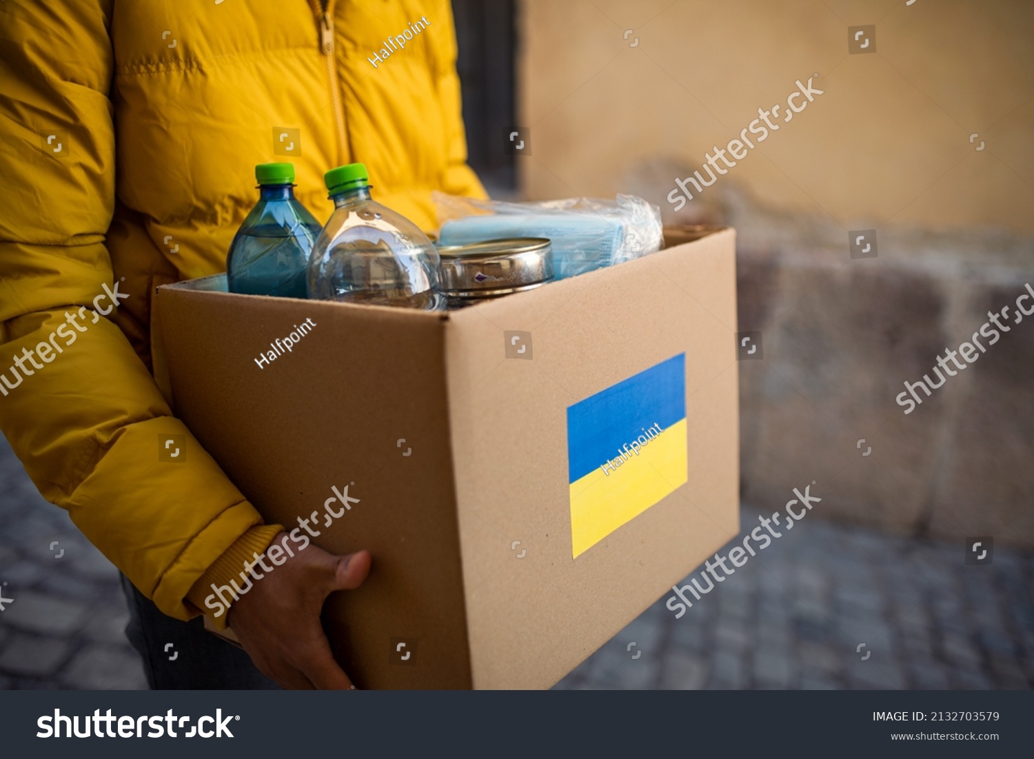 Close up of volunteer cyrrying box with Humanitarian aid for Ukrainian refugees in street #2132703579