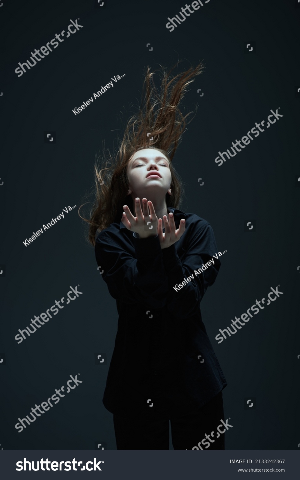Art portrait of a beautiful young girl with long flying hair and closed eyes. The inner world of a human, emotions. Thoughtfulness, meditation. Studio portrait on a dark background. #2133242367