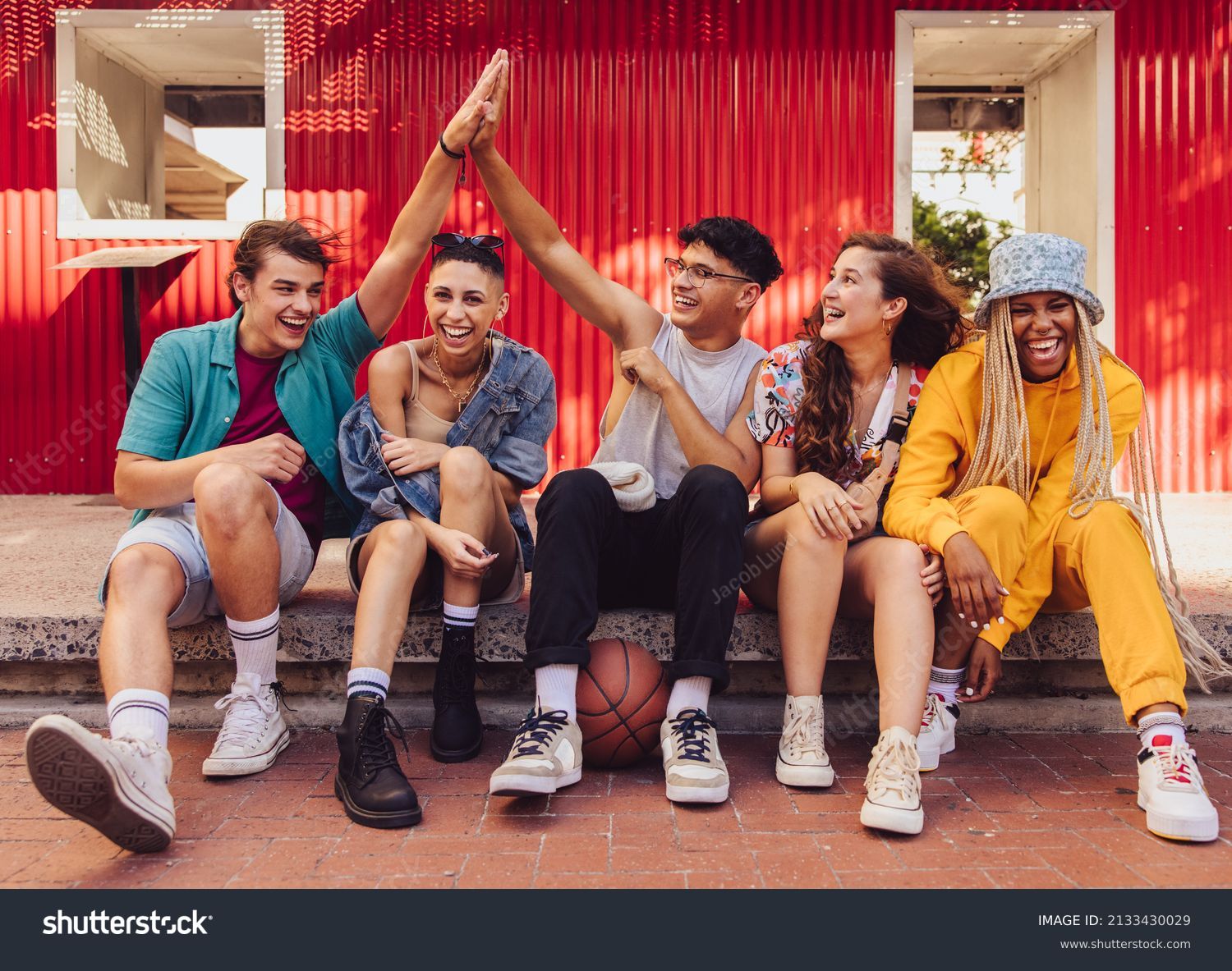Here's to friendship. Group of multiethnic young people enjoying hanging out together outdoors in the city. Cheerful generation z friends having fun and making happy memories. #2133430029