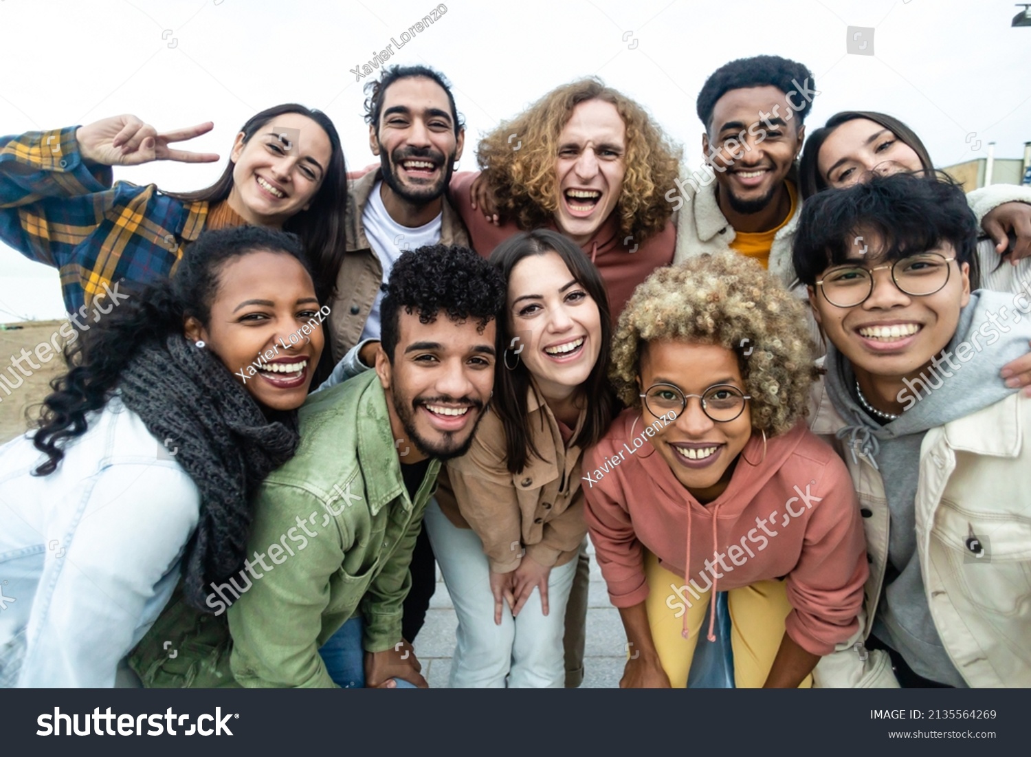 Happy group of multiethnic young friends - Diverse people smiling at camera outdoors - Community and unity people concept #2135564269