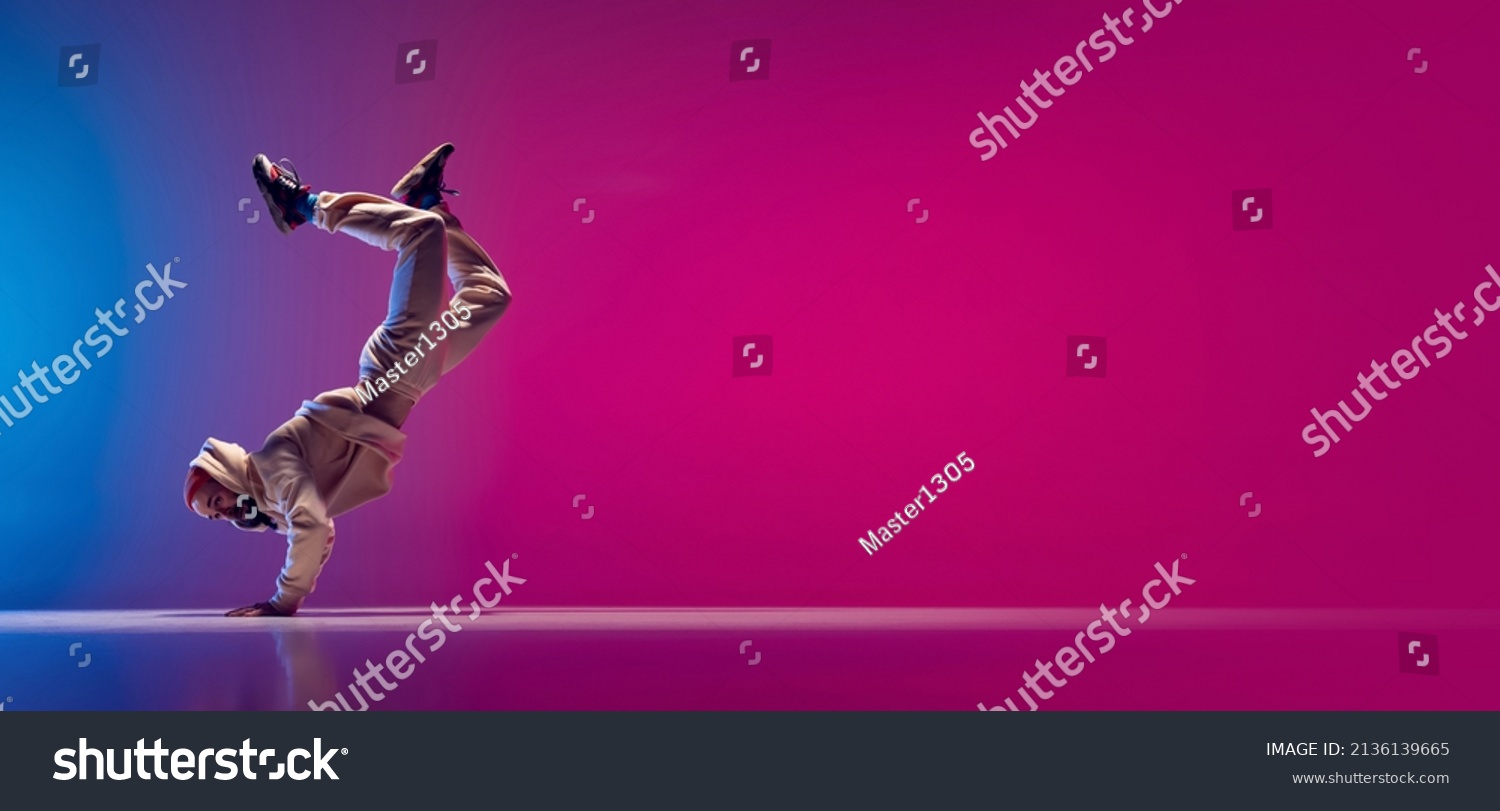 Flyer with young flexible sportive man dancing breakdance in white outfit on gradient pink blue background. Concept of action, art, beauty, sport, youth. Dancer shows breakdance figures #2136139665
