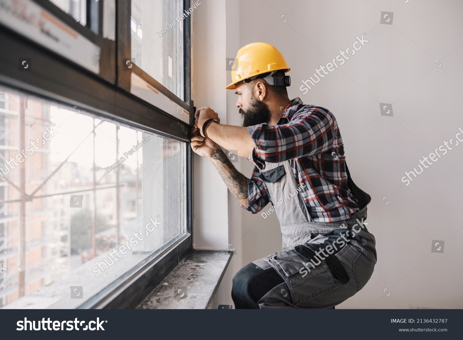 A repairman fixing windows in new apartment. #2136432787