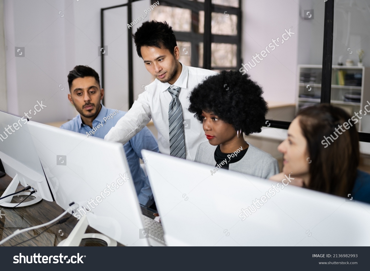 Group Of Happy Business People Using Laptop Discussing At Workplace In Office #2136982993