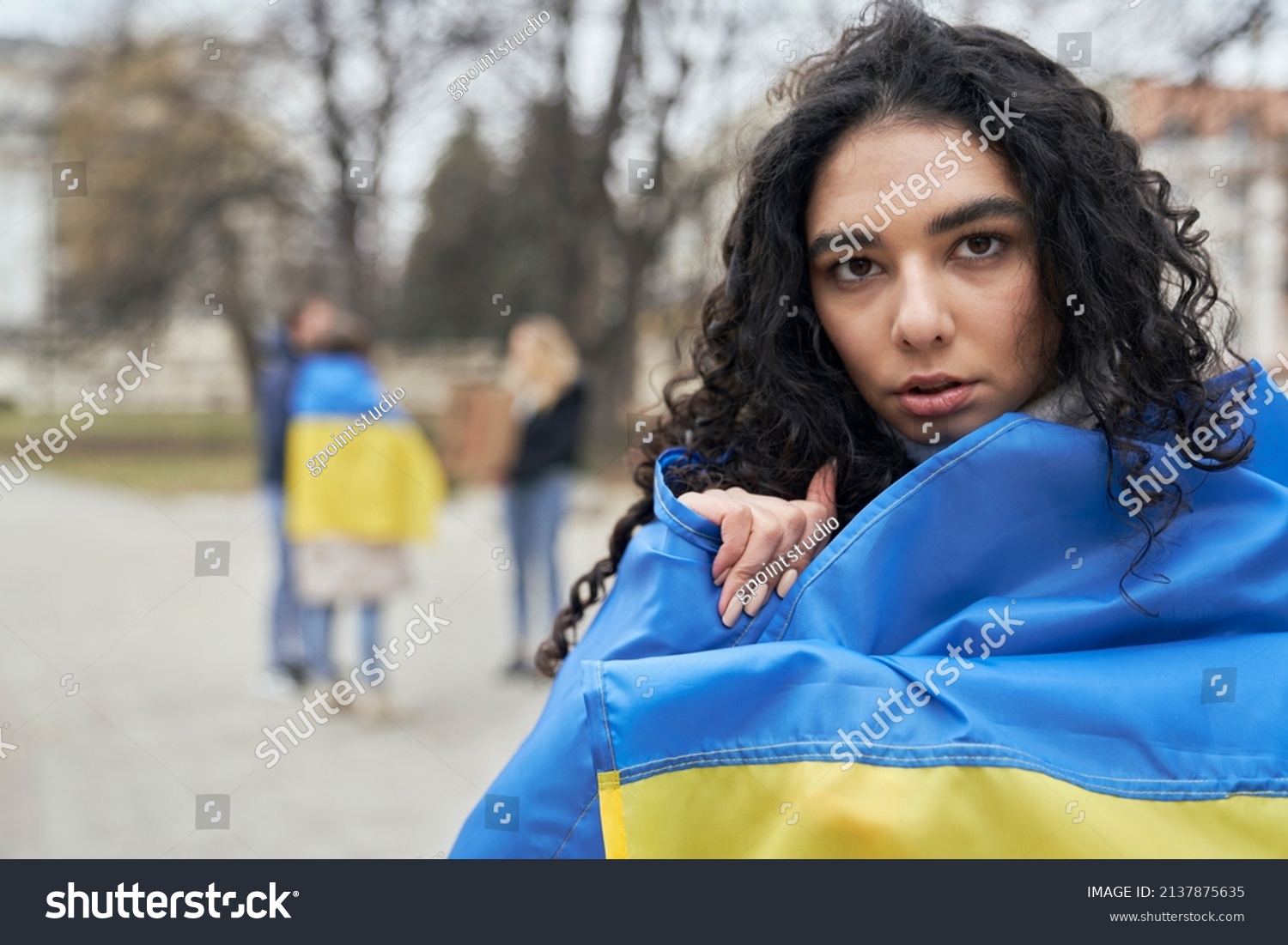 Woman in front of group of young caucasian people manifesting against war in Ukraine #2137875635