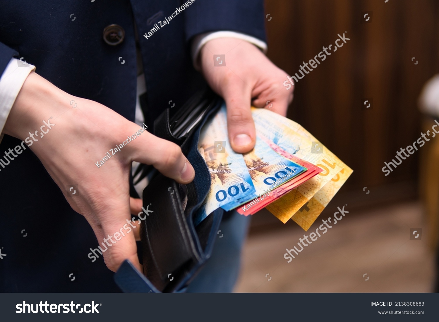 businessman holds Swiss francs in various denominations. Placing your savings in Swiss francs as a safe and stable currency #2138308683