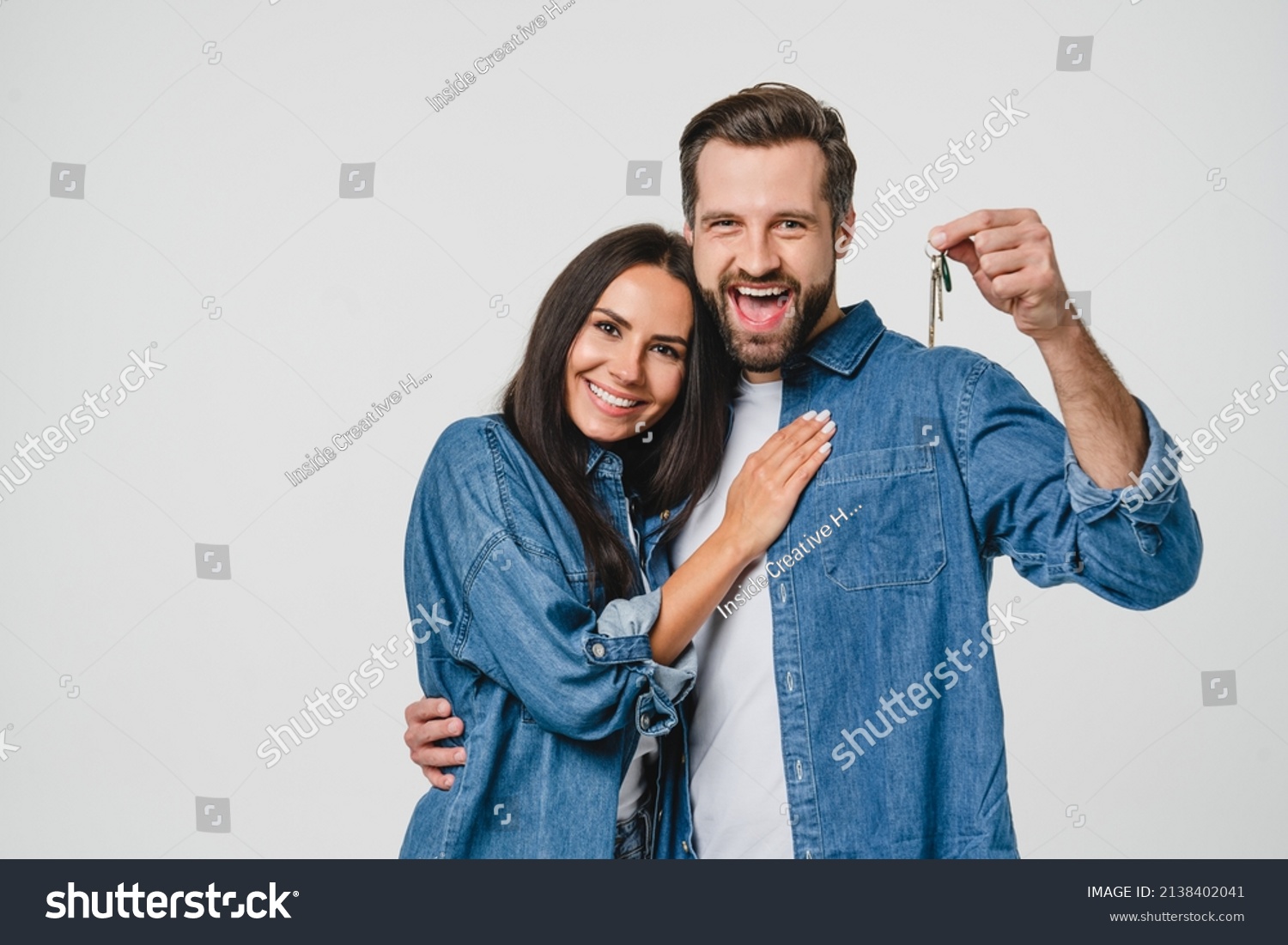 Homeowners. Happy young caucasian couple spouses wife and husband holding car house flat appartment keys, celebrating new purchase buying real estate isolated in white background. Mortgage loan #2138402041